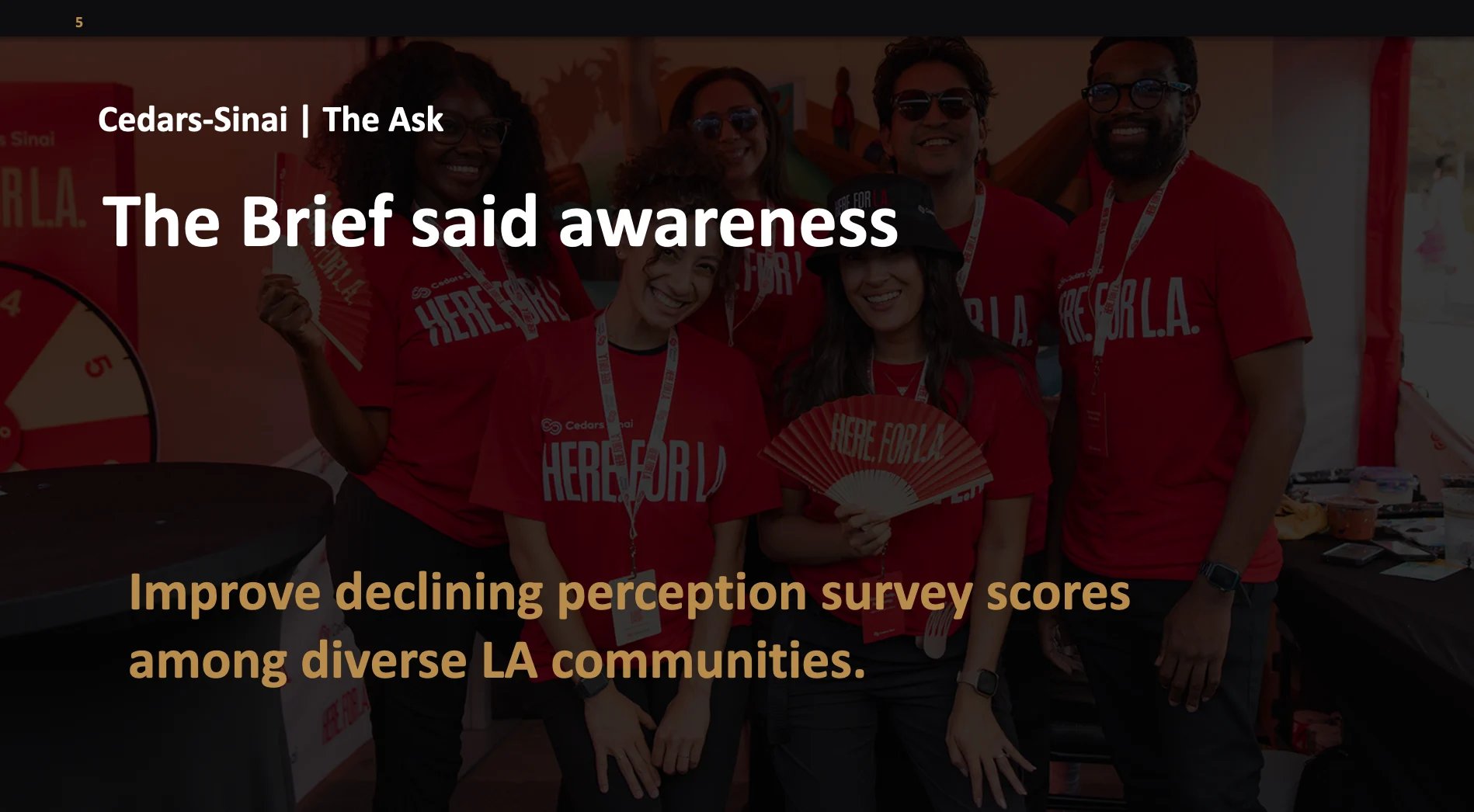 Group of people wearing red shirts at a community event for Cedars-Sinai discussing awareness initiatives for LA communities