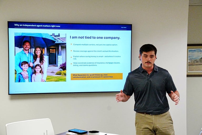 Man in dark shirt presenting slide about independent agent status to audience
