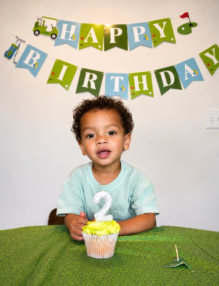 Toddler celebrating second birthday with cupcake and Happy Birthday banner