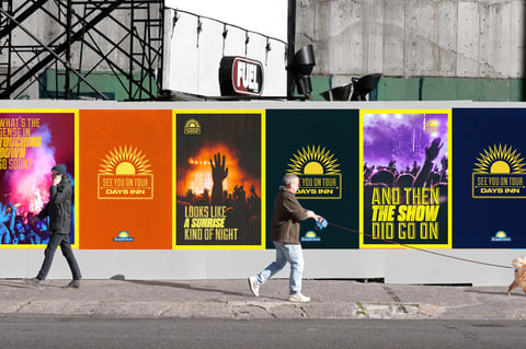 Street scene with pedestrians walking past colorful movie festival promotional posters on a concrete wall