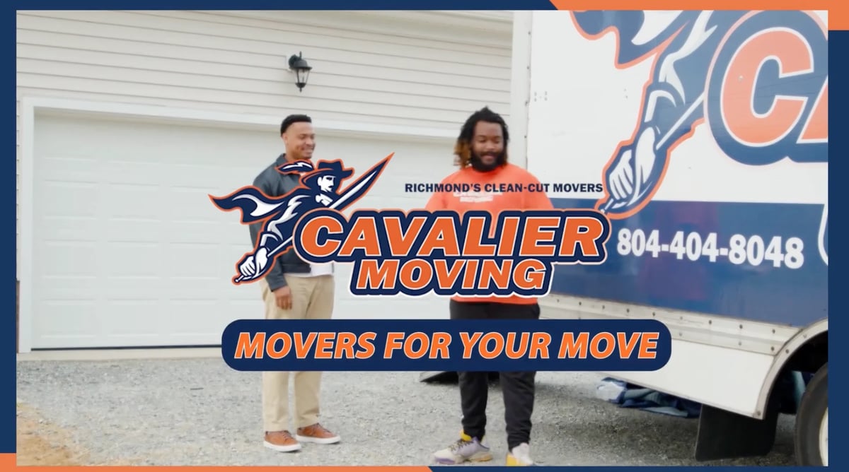 Two people standing in front of a Cavalier Moving truck displaying the company logo and tagline Movers for Your Move